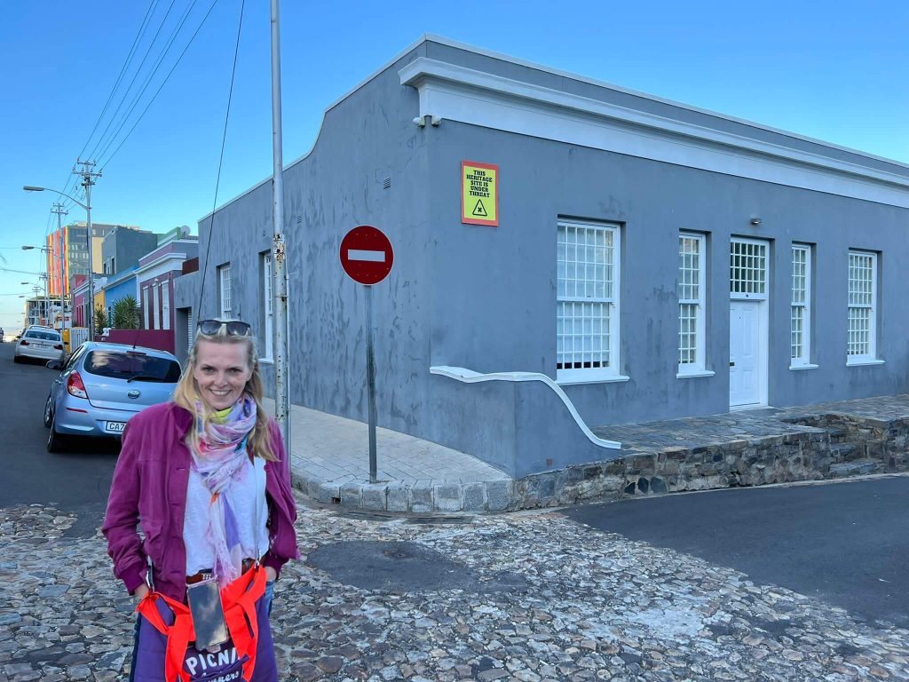 Eine Frau vor einem Haus im bekannten Stadtteil Bo-Kaap in Kapstadt.